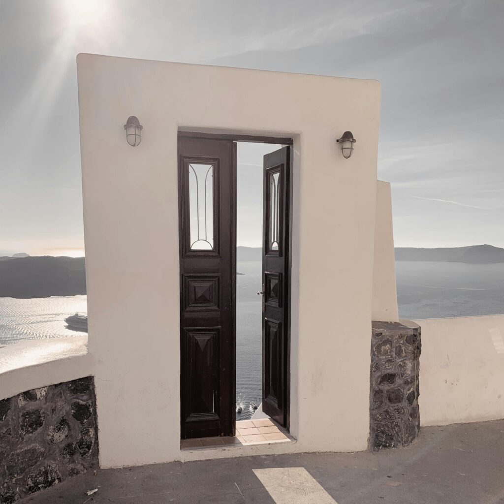A classic Santorini doorway opens to reveal a stunning sea view, capturing Greece's tranquil beauty.